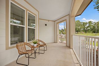 A patio with two chairs and a table on a balcony